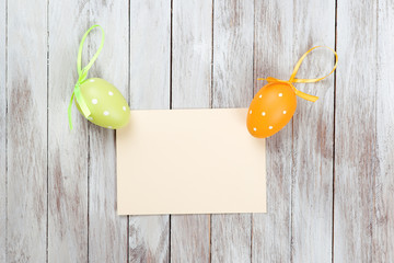 Easter background with blank card on wooden background.