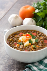 Lentil soup in a bowl on wooden background
