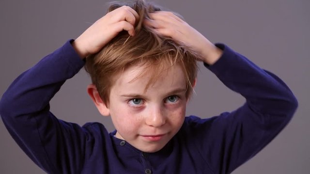 thinking cute small male preschooler scratching his head for reflection