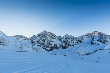 Fototapeta na wymiar Ski winter season, ski run in Italian Alps. Solda with Ortler, Zebru, Grand Zebru in background. Val Venosta, South Tirol, Italy. 