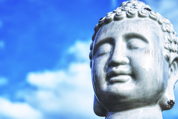 Buddha - ein Kopf vor einem blauen Himmel, als Symbol des Buddhismus. 
