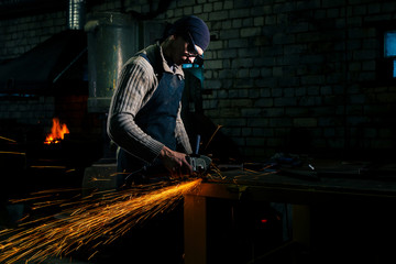 Sparks flying over the working table during metal grinding.