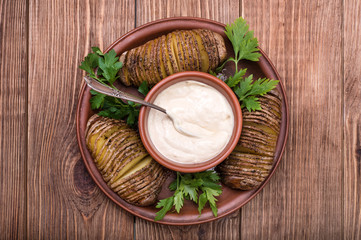 Baked potatoes with sauce on plate .
