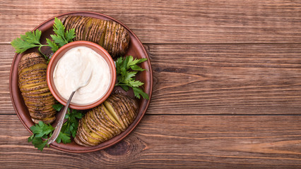 Baked potatoes with sauce on plate .