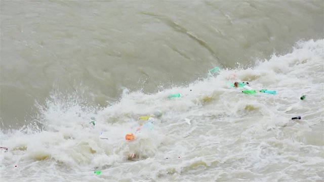 Plastic bottles, football balls and others objects polluting the water environment. Tiber river, Rome, Italy
