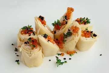 Close up view of pancakes with salmon and caviar on big white pl