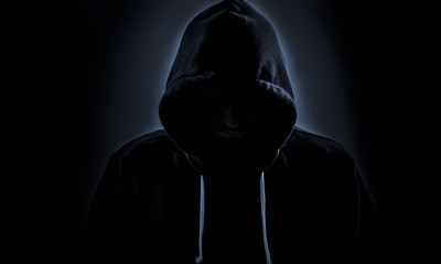 Hooded hacker in dark