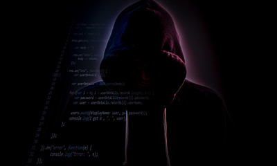 Hooded hacker in dark with code