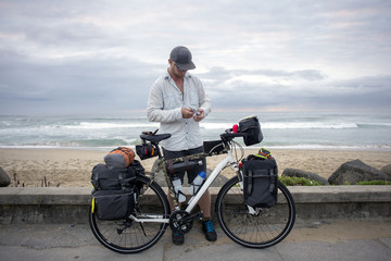 Fototapeta premium Long Distance Cyclist with Bicycle by Ocean