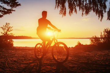 boy on a bicycle at sunset
