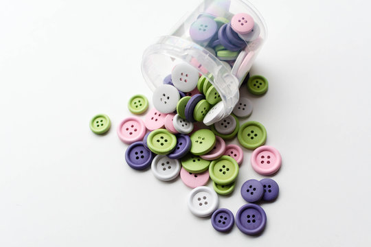 plastic can and colorful buttons and white background