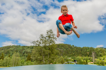 Young boy jumping on bouncing pillow