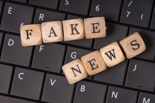 Fake News / Tastatur und Holzwürfel mit den englischen Worten Fake News