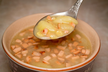 dry peas soup with potatoes in a spoon