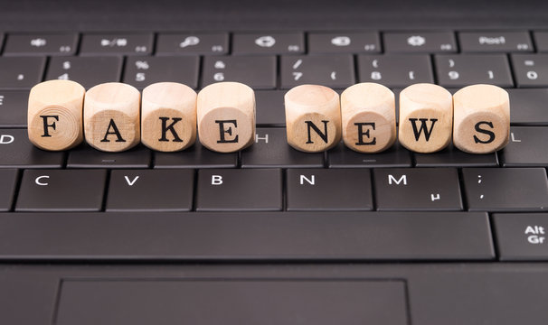 Fake News / Tastatur und Holzwürfel mit den englischen Worten Fake News