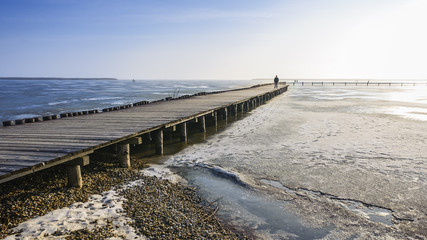 Obraz premium Mann auf der Mole am Neusiedlersee mit Eis