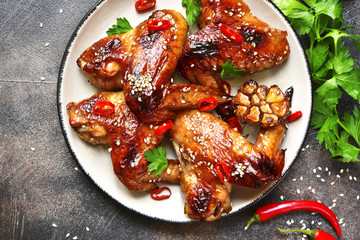 Spicy chicken wings with teriyaki sauce and sesame seeds on a vi