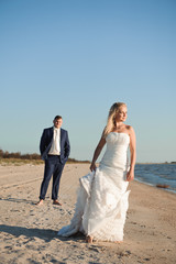 Fototapeta na wymiar Bride and groom by the sea on their wedding day