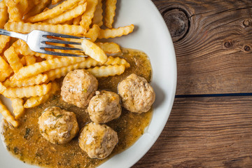 Meatballs with french fries in dill sauce.