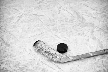 Foto op Plexiglas Closeup of one hockey stick and puck laying on textured ice in black and white © kat7213