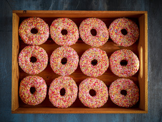 Iced doughnut rings with rainbow sparkl strands.