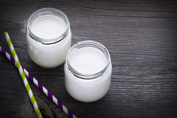 Fresh homemade yogurt with color tubules on old wooden table