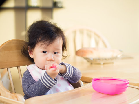 baby girl eating  mashed vegetable  first time at home