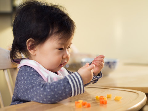 baby girl eating  vegetable first time at home