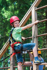 Mit Sicherheit aufwärts - Junge präsentiert sich stolz im Kletterpark