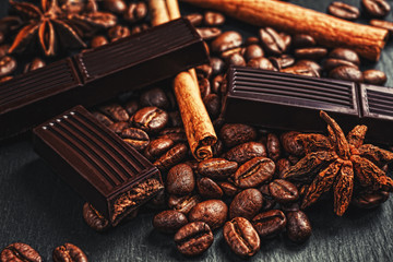 Coffee cup, spices and chocolate on wooden table texture with co