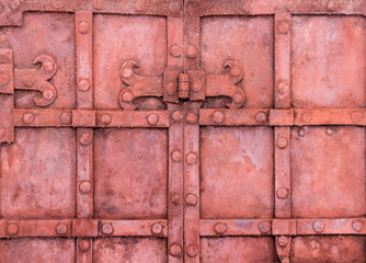 The hinge on an old metal gate red color