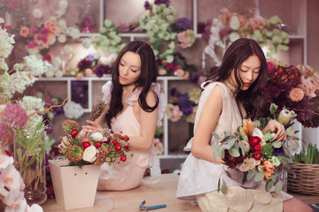 Beautiful asian women florists with bouquet of flowers in flower store