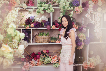 Beautiful asian woman florist in pink dress in flower store