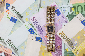 gold woman clock on euros bills. close up.