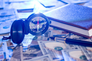 compass on usa hundred dollars with note, pen. journey concept.