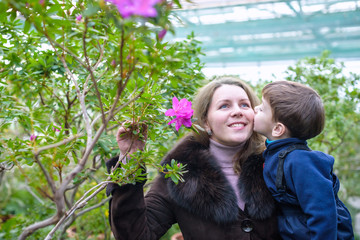 Fototapeta premium Beautiful woman holding her little adorable kid boy in the bloom