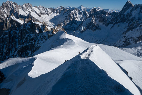 Climber ascending arete in way up to Aiguille du Midi with Valle