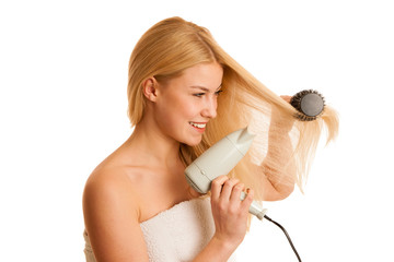 Blonde woman drieing her hair with air blower isolated over whit