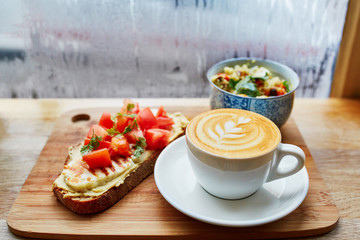 Hummus and tomato sandwich, salad and fresh hot cappuccino coffee