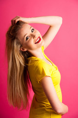 Cute young blonde teenage woman pose over pink background in vib