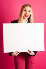Young business woman holds blank banner isolated over pink backg