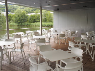 
Restaurant im Grünen mit Tischen und Sesseln und schöner Aussicht 