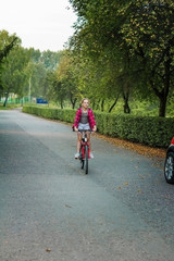 Fototapeta premium Girl child 10 years old on a Bicycle in the Park.