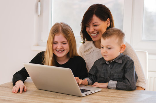 Mother With Kids Playing On Laptop Computer