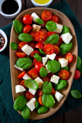 caprese salad on dark wooden surface