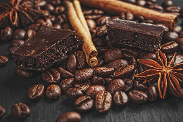 Coffee cup, spices and chocolate on wooden table texture with co