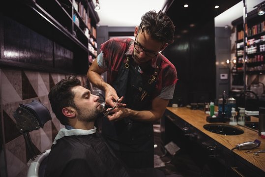 Man getting his beard trimmed with scissor