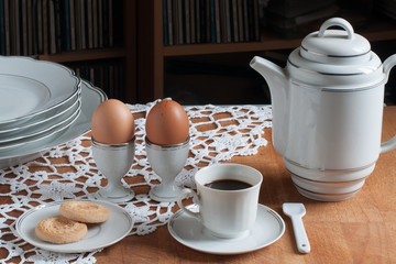 Colazione con le uova, caffè e biscotti con servizio bianco