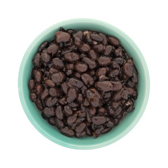 Top view of organic black beans in a green bowl isolated on a white background. 