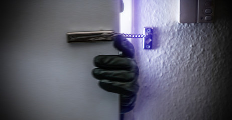 Einbrecher öffnet Wohnungstüre mit Türkette
